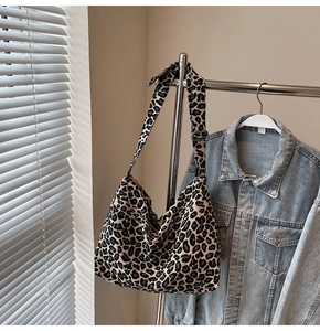 Detail of adjustable black metal buckle and durable strap on leopard print canvas bag