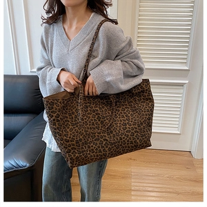 Detailed view of leopard print tote bag being worn over the shoulder in a living room