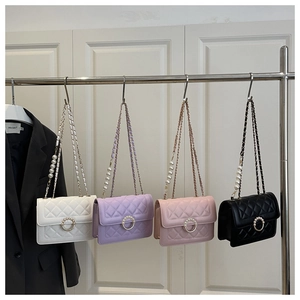 Close-up of quilted chain bags in white, purple, pink, and black with pearl buckles