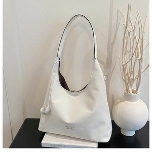 Detail of white matte leather tote bag with metal buckle and logo on minimalist background