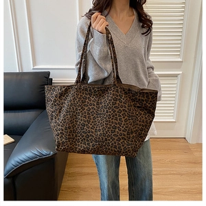 Detailed view of lightweight leopard print tote bag with soft handles on a shoulder