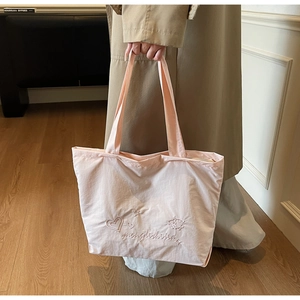 Détail du grand sac cabas rose clair avec broderies de cœurs et anses en toile souple