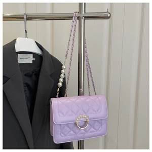 Close-up of lavender quilted leather bag with pearl embellishments and gold ring hardware