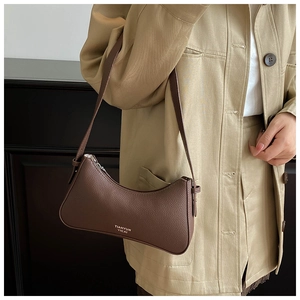 Detailansicht der kaffeebraunen Lederstruktur mit Lychee-Muster einer Schultertasche