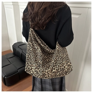Detail shot of large leopard print canvas tote bag on a model in a minimal setting