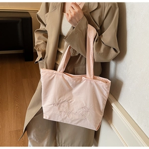 Gros plan du sac cabas rose clair avec broderie délicate de cœurs et d'étoiles