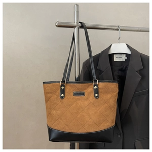Detailed view of checkered quilted brown suede tote bag with black leather stitching details
