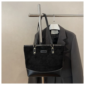 Detail of checkered quilted tote bag with suede texture and contrast leather bottom