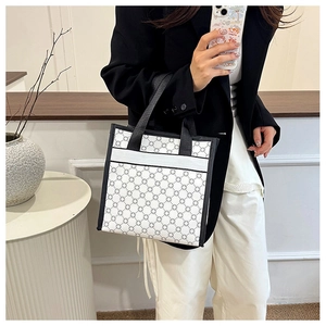 Detailed shot of floral print tote bag with black strap accents and handy front pocket