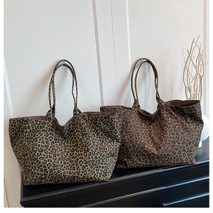 Close-up of two large leopard print canvas tote bags in light and dark brown patterns