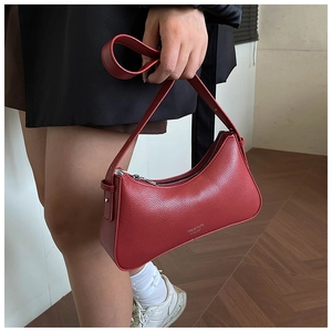Detail der roten Halbmond-Achseltasche mit Lychee-Leder und goldenem Logo-Druck