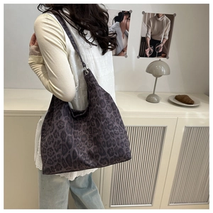 Close-up of a large purple leopard print tote bag with soft texture on a shoulder