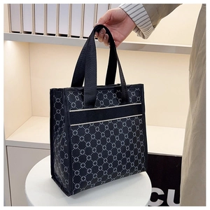 Detail of black geometric pattern tote bag with white stripes on a display stand