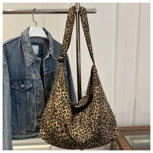 Detailed view of leopard print canvas tote bag with adjustable strap and buckle