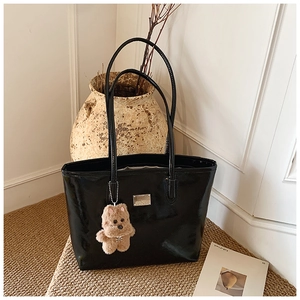 Polished black tote bag with silver metal plate and brown plush bear charm
