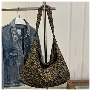 Detailed close-up of large leopard print canvas hobo bag with adjustable wide shoulder strap