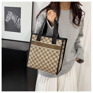 Detail of a chic canvas tote bag with M-letter jacquard pattern and contrast trim handle