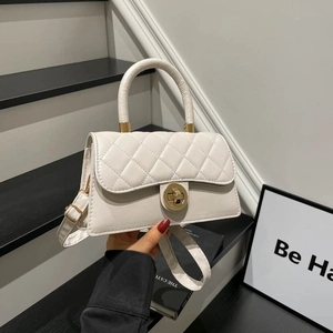 Elegante bolso acolchado blanco con cierre dorado en una moderna escalera