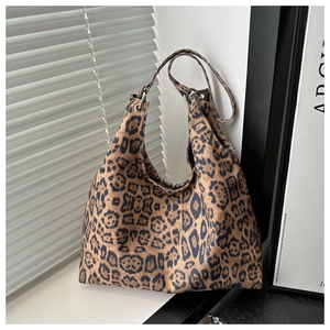 Detailed view of leopard print canvas hobo bag featuring metal ring buckle and leather handle