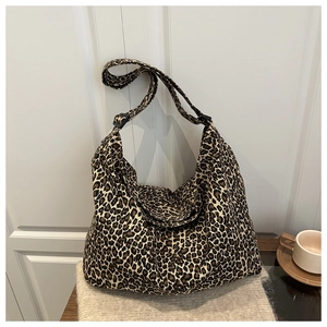 Detail of hobo bag featuring leopard print canvas, wide strap and adjustable buckle