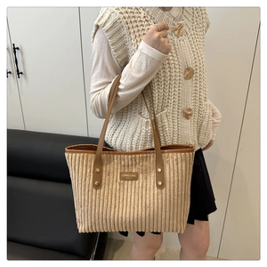 Close-up van kaki corduroy draagtas met gestructureerde stof en bruin leren handvat