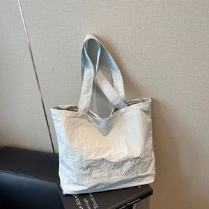 Sac fourre-tout en tissu plissé minimaliste avec broderie élégante sur fond texturé