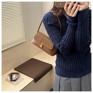 Detail of leopard print suede shoulder bag with gold clasp shown on model