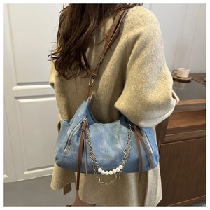 Light blue denim tote bag with brown leather straps and elegant pearl chain detail