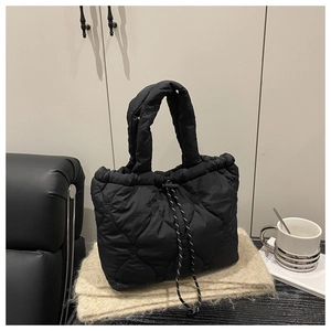 Close-up of black quilted dumpling bag with heart pattern and drawstring detail