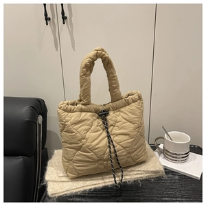 Detail of heart-shaped quilted beige tote bag with a soft texture and drawstring closure