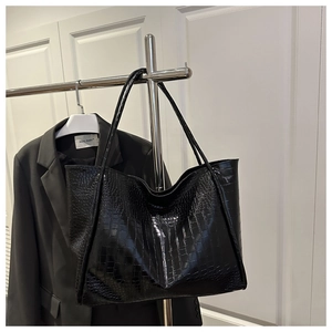 Close-up of premium black crocodile embossed texture on large leather tote bag