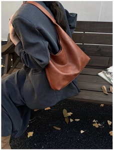 Detail of a brown vintage tote bag with high-texture leather and FASHION & BAGS embossing