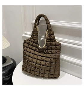 Macro detail of brown quilted tote bag with soft padded texture and interior lining