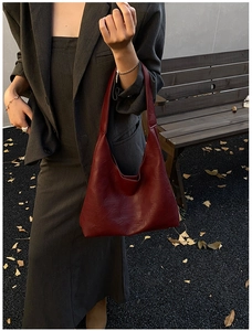 Macro detail of wine red leather tote bag showing fine texture and fashion embossing
