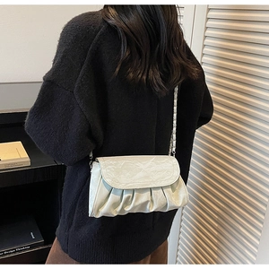 Detailed view of the pleated PU leather texture and woven chain strap on a crossbody bag