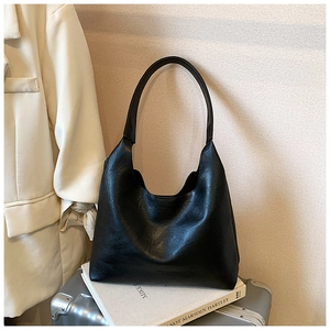 Detail of black pebbled leather hobo bag with wide strap for office and travel use