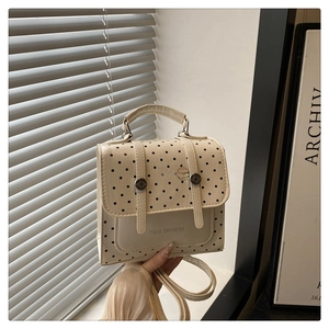 Detail of a beige polka dot bag featuring Tidal Dryness text and a burger graphic