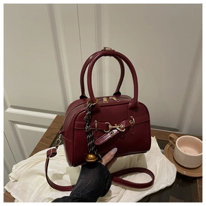 Détail du sac bowling bordeaux vintage avec mors doré et foulard en soie élégant