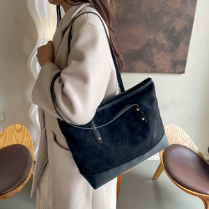 Détail d'un grand sac cabas en daim noir avec motif matelassé avec clous en métal noir vintage