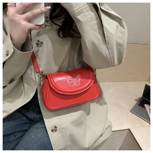 Detail shot of the red butterfly embroidery on a stylish underarm shoulder bag