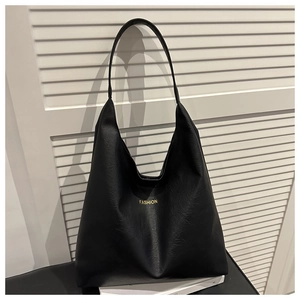 Detail view of large black oil wax leather tote bag with gold fashion lettering