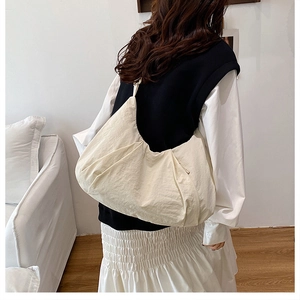 Detailed view of the large off-white tote bag with a stylish pleated texture on a model