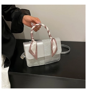 Detail of silver crossbody bag with sequin patchwork and checkered silk scarf handle