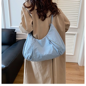 Minimalist light blue large capacity tote bag shown on shoulder in modern room