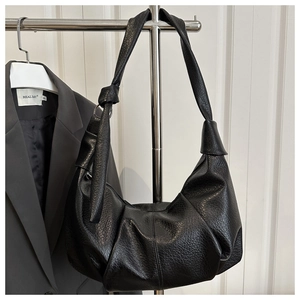 Detail of black cloud shoulder bag featuring textured lychee grain leather and knotted strap