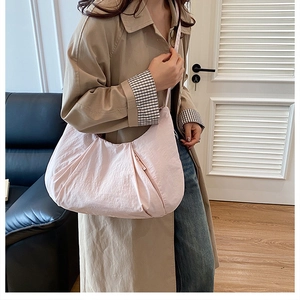 Detail of light pink crescent hobo bag with pleated texture and functional zip pocket