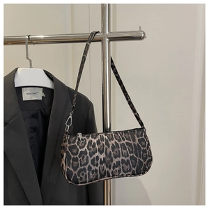 Détail du sac léopard sous l'aisselle avec fermeture éclair sur fond de blazer noir