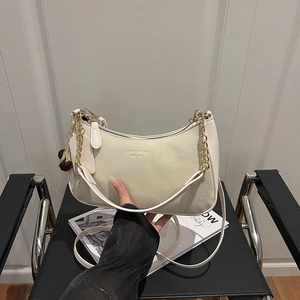 Sac bandoulière chic en daim beige avec chaîne dorée et pendentif cerise