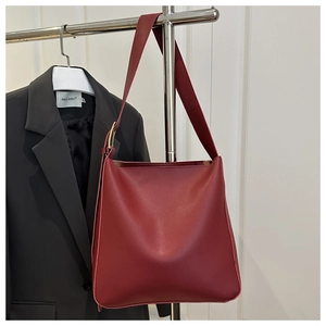 Detail view of burgundy PU leather tote bag with wide strap and gold metal buckle