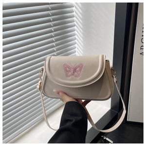 Detailansicht der rosa Schmetterlingsstickerei auf einer beigefarbenen quadratischen Tasche